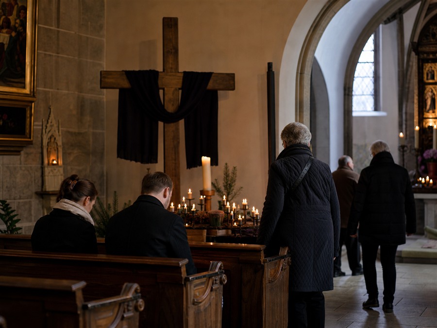 Schlichte Kreuzwegstimmung mit Kerzen und Holzkreuz am Karfreitag